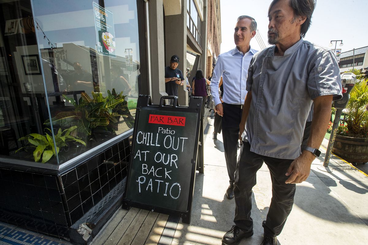 Don Tahara, right, owner of Far Bar restaurant on 1st St. in the Little Tokyo section of Los Angeles, gives a tour of his establishment to Los Angeles Mayor Eric Garcetti.