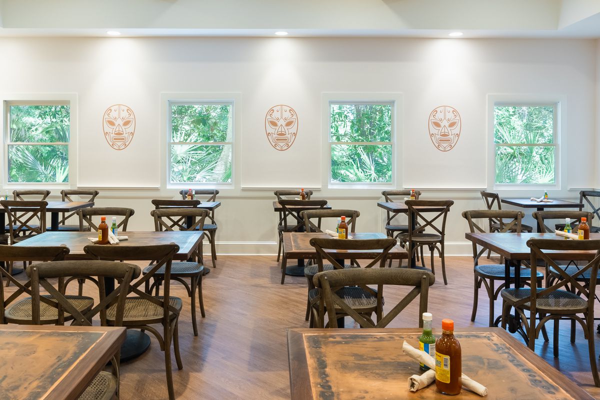 A dining room with luchadora masks outlined on the walls. 