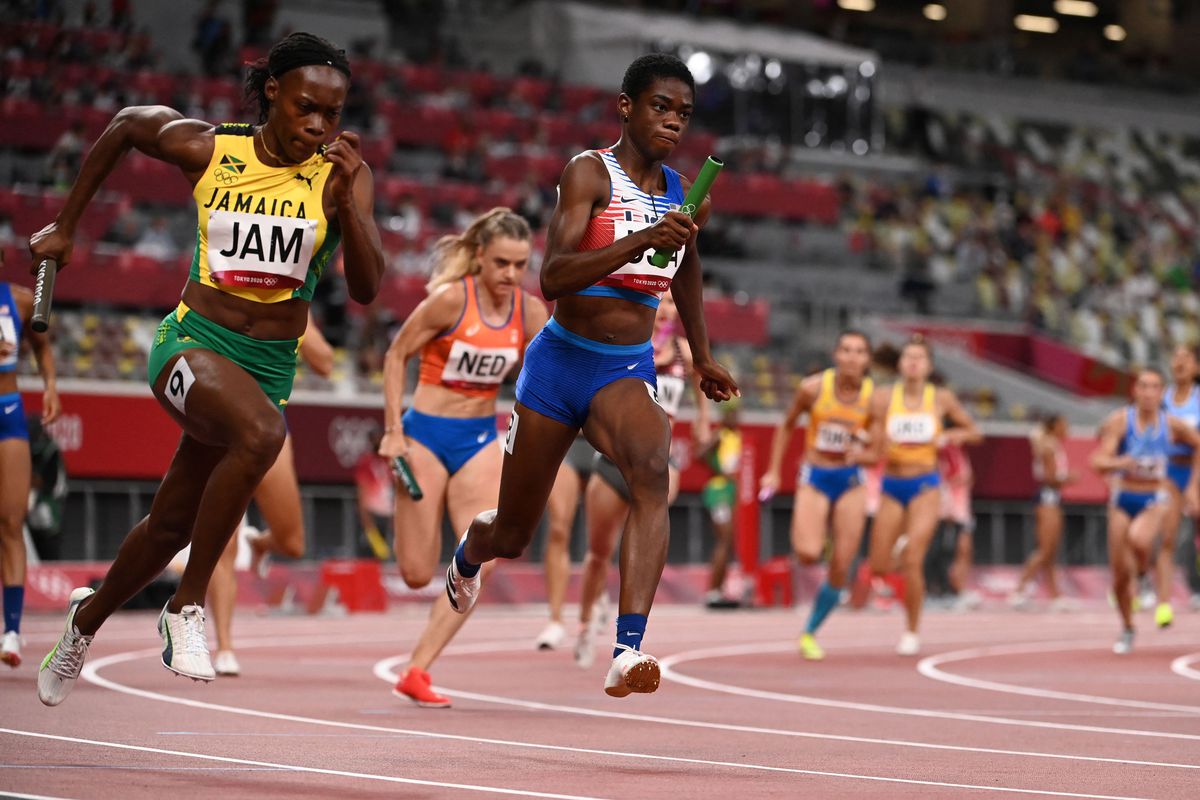 Jamaica’s Roneisha McGregor (L) and USA’s Wadeline Jonathas compete in the women’s 4x100m relay heats during the Tokyo 2020 Olympic Games at the Olympic Stadium in Tokyo on August 5, 2021.