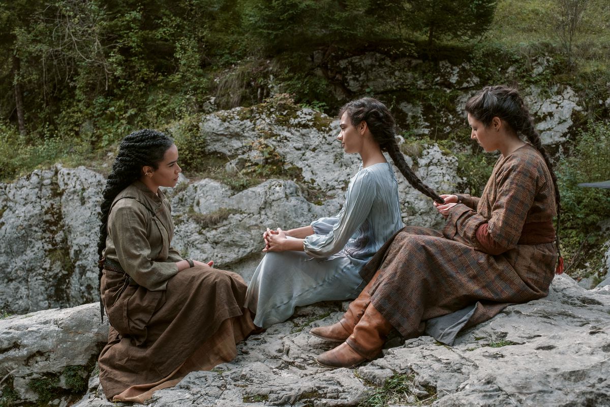 Nynaeve watches as a woman braid’s Egwene’s hair in a still from the pilot episode of The Wheel of Time