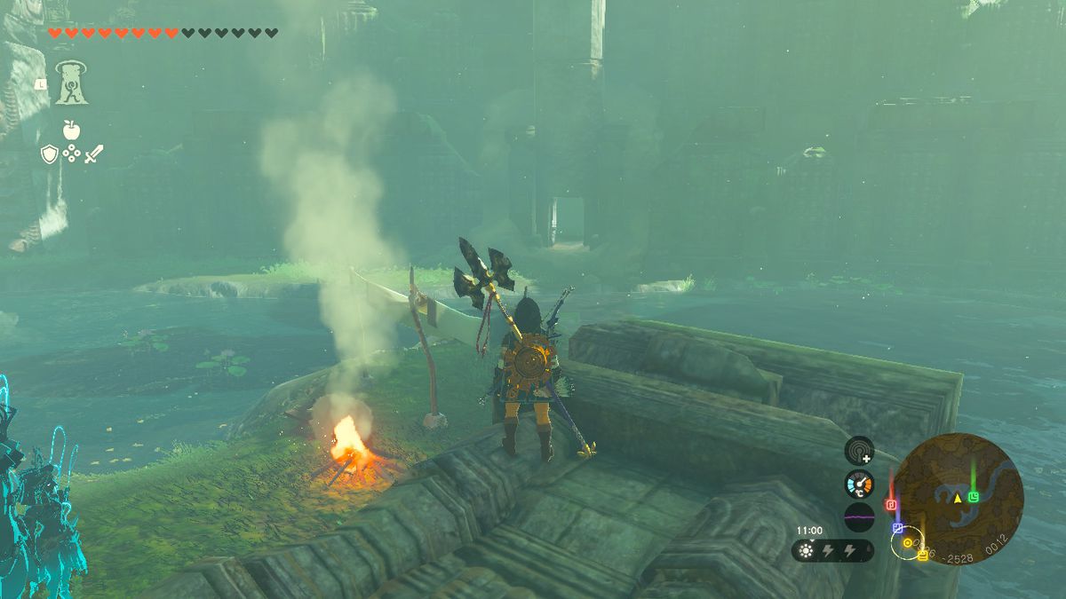 Link stands next to a campfire by Dracozu Lake in Zelda Tears of the Kingdom.