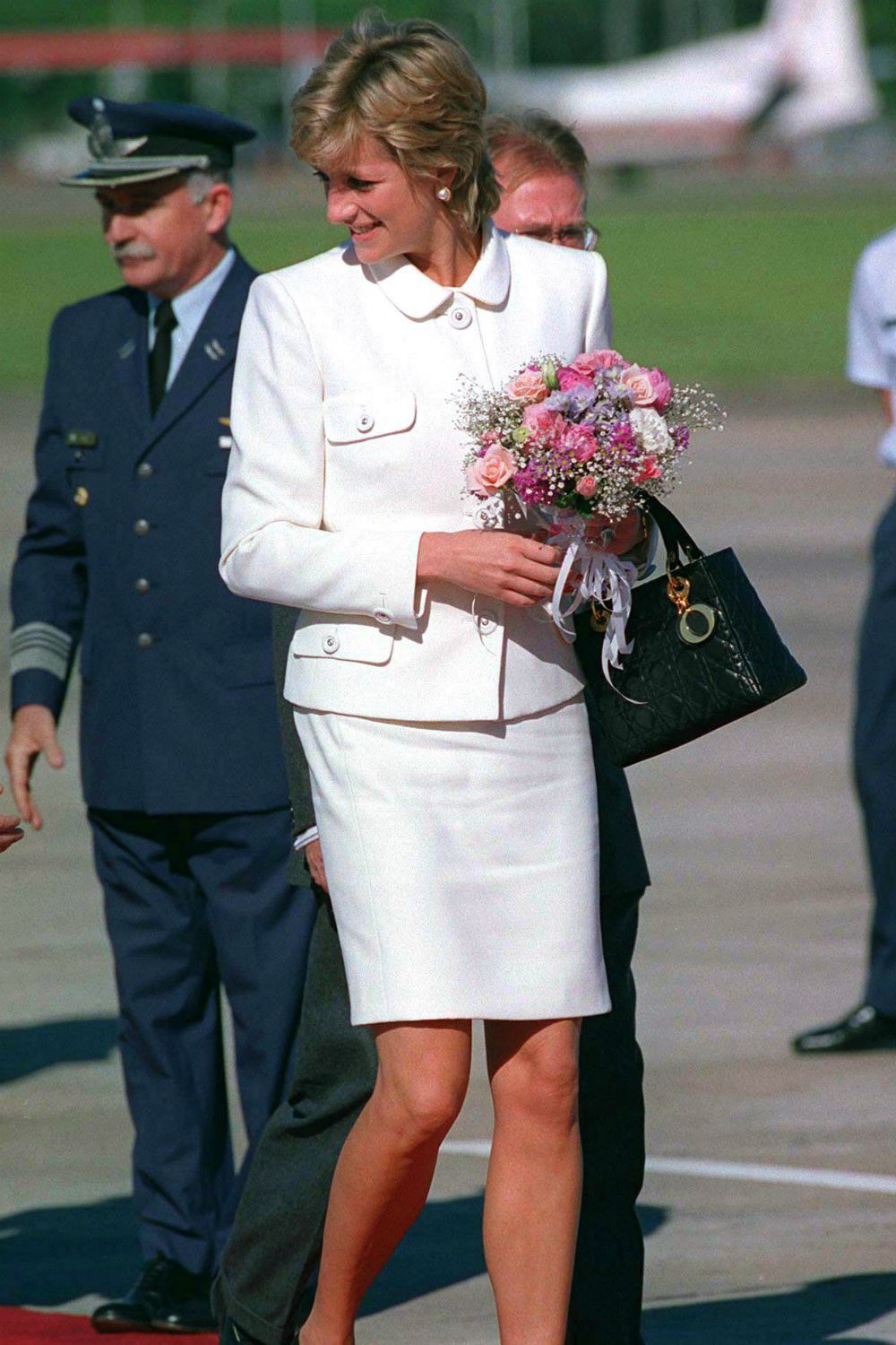 Princess Diana with flowers, wearing a white suit