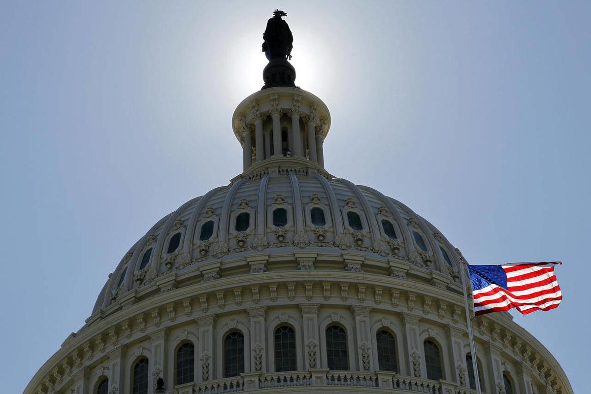 In this July 14, 2011 photo, the U.S. flag flies next to the Capitol in Washington, as Congress and the Obama Administration continued work to raise the debt ceiling. 