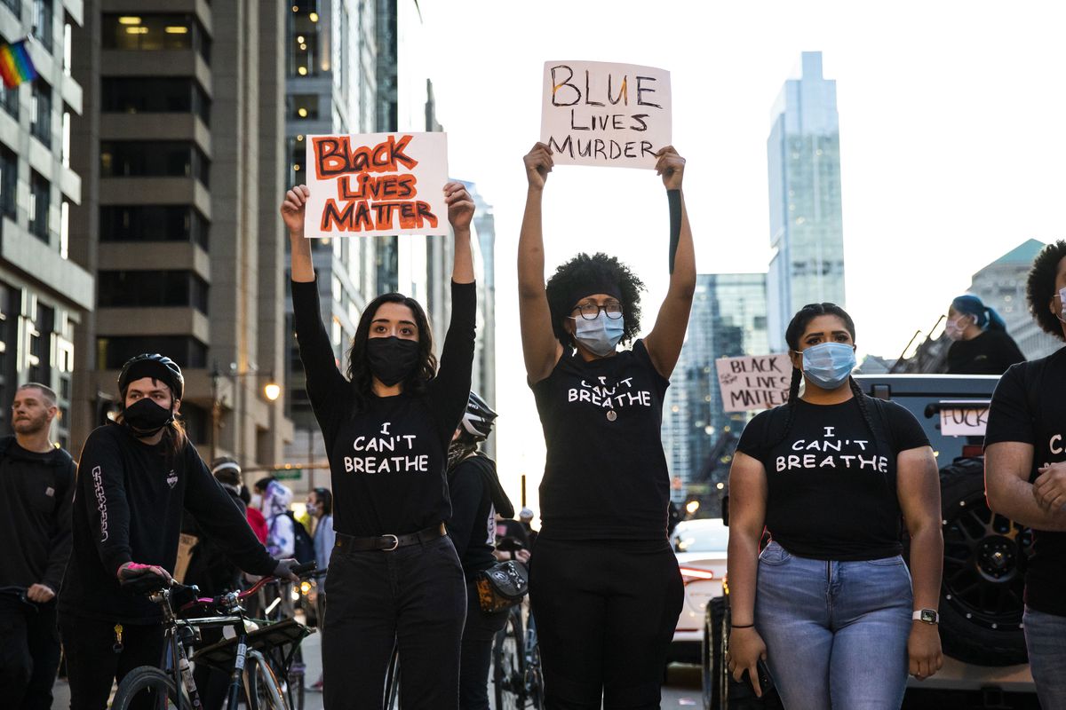 Protesters hold placards in Chicago in May of 2020 as they join national outrage over the death of George Floyd.