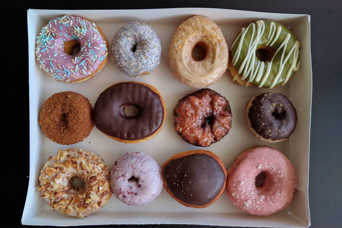 A box of Morningstar doughnuts covered in colorful glazes and sprinkles