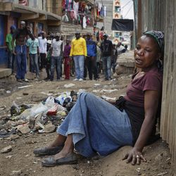 A relative wails on the floor of an alleyway near to the body of a man who had been shot in the head and who the crowd claimed had been shot by police, as the angry crowd shouts towards the police, in the Mathare slum of Nairobi, Kenya Wednesday, Aug. 9, 2017. Kenya's election took an ominous turn on Wednesday as violent protests erupted in the capital. (AP Photo/Ben Curtis)