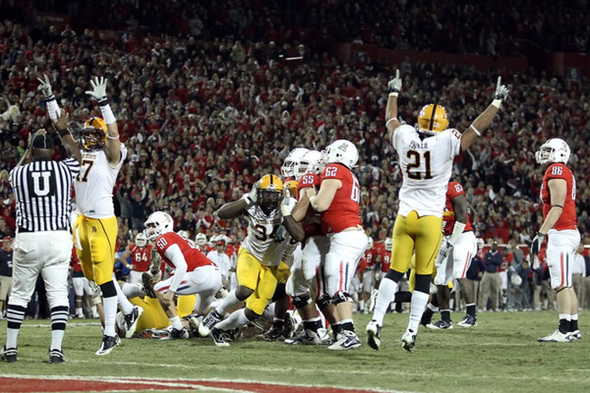Defensive end James Brooks #34 (C) and the Arizona State Sun Devils celebrate blocking an extra point to defeat the Arizona Wildcats in double overtime on December 2 2010 in Tucson Arizona. (Photo by Christian Petersen/Getty Images)