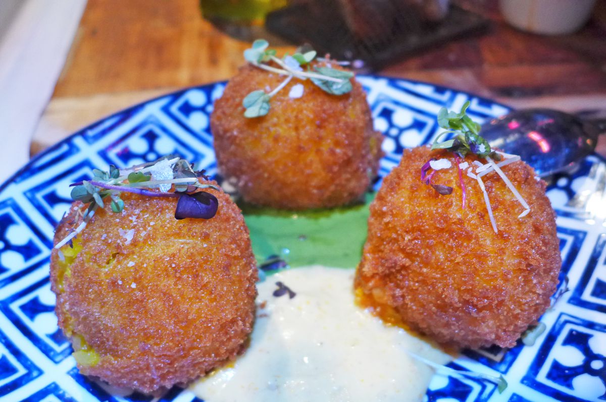 The well-browned rice balls with green and white sauces underneath.