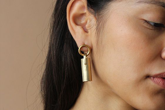 Gold earrings on a model with black hair