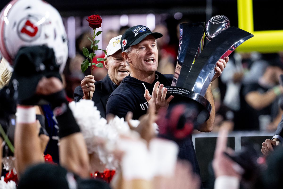 Utah coach Kyle Whittingham hoists Pac-12 trophy after Utes beat the Oregon in the Pac-12 championship game.