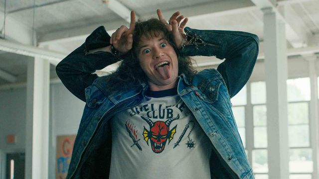 Eddie sticks out his tongue and makes devil horns with his hands in a scene from Stranger Things season 4
