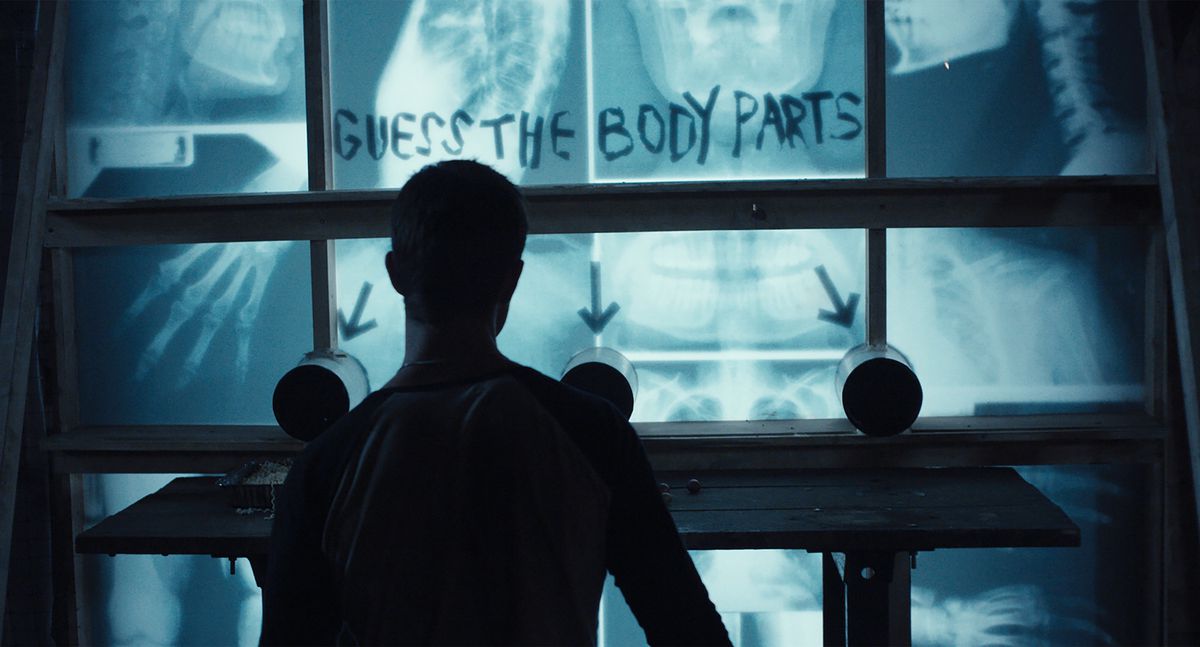 A “guess the body part” haunted house gag papered with x-ray scans of human bones in the new movie haunt