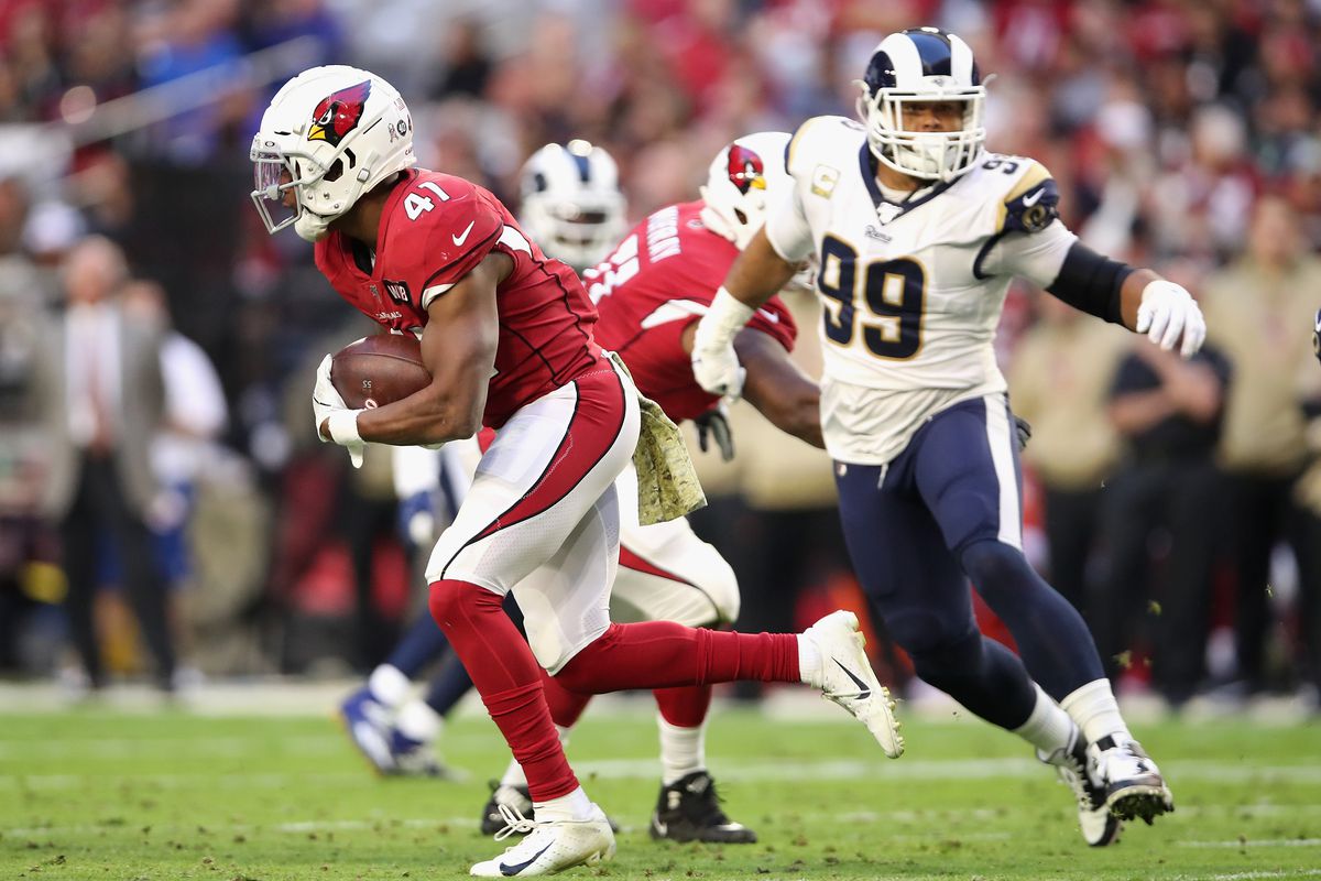Running back Kenyan Drake of the Arizona Cardinals rushes the football past defensive tackle Aaron Donald of the Los Angeles Rams during the second half of the NFL game at State Farm Stadium on December 01, 2019 in Glendale, Arizona.