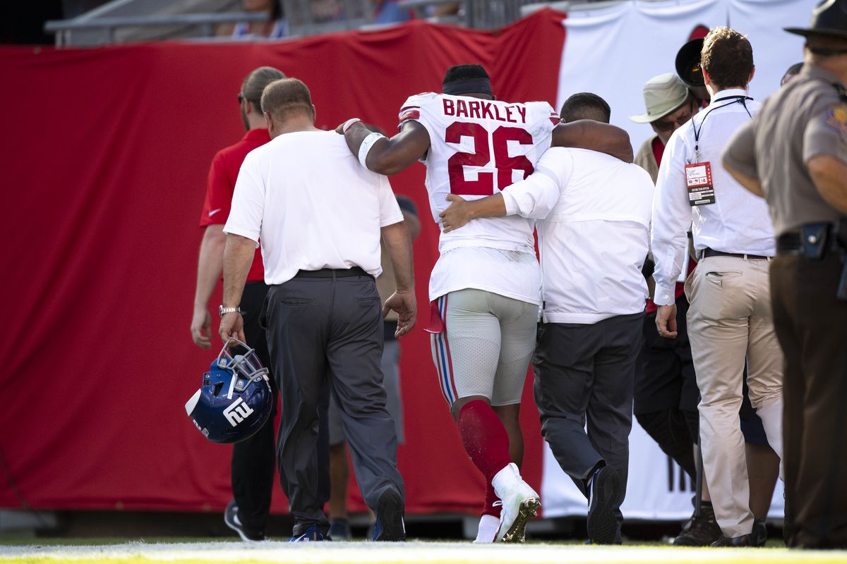 New York Giants running back Saquon Barkley is assisted off the field after suffering an apparent injury during the second quarter against the Tampa Bay Buccaneers at Raymond James Stadium.