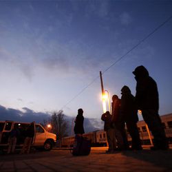 In this photo taken  Feb. 3, 2010 homeless men and women stand in line to be searched before being bused to local churches serving as shelters in Riverhead, N.Y.