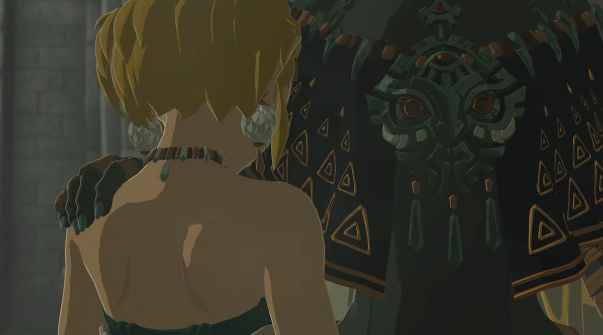 A still from a trailer for The Legend of Zelda: Tears of the Kingdom. It shows a tall person putting their hand on Zelda’s shoulder, but we can’t see their face.
