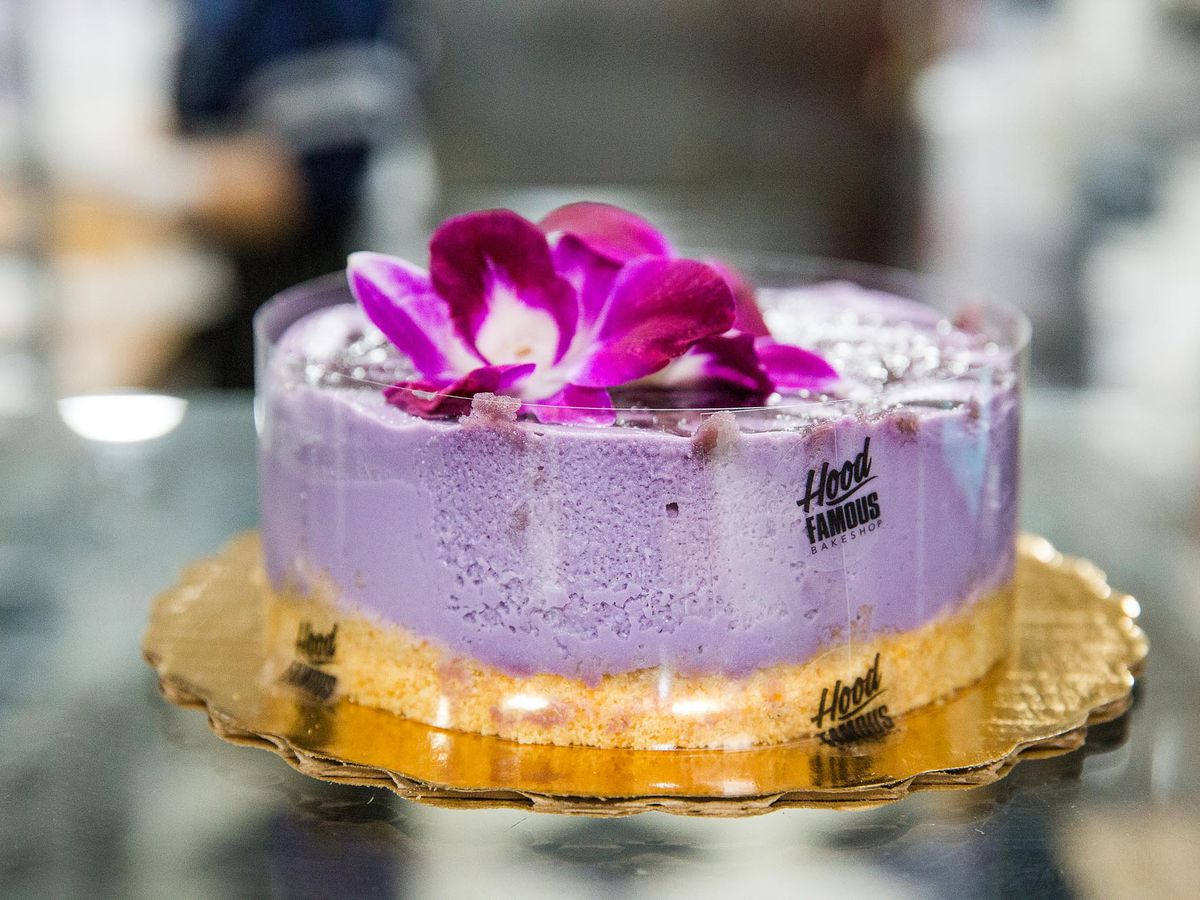 A purple ube cheesecake with a colorful flower on top.