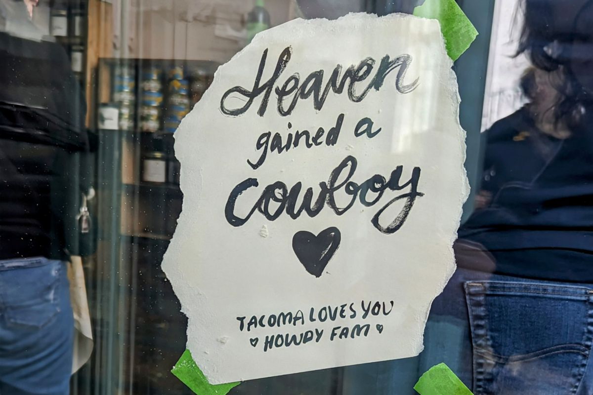 A sign reading “Heaven Gained a Cowboy.”