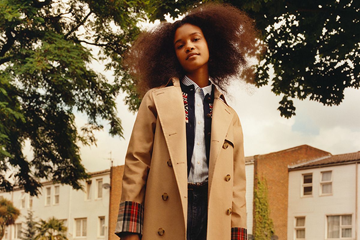 A model wearing a plaid accented trench coat from the JW Anderson x Uniqlo collaboration.