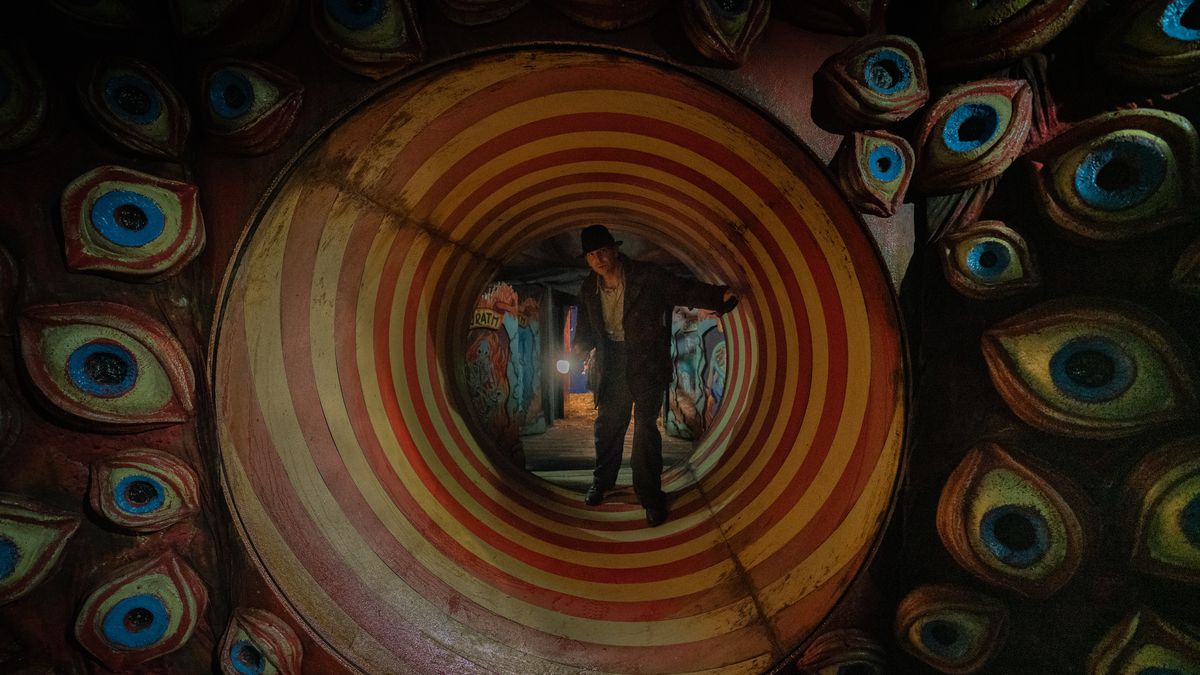 Bradley Cooper as Stan Carlisle in a funhouse tunnel surrounded by eyes in Guillermo del Toro’s Nightmare Alley.