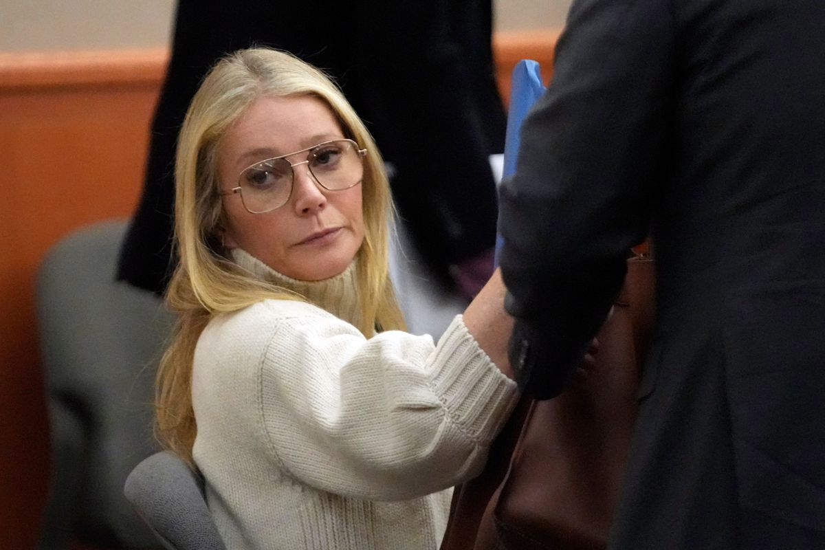 Gwyneth Paltrow sitting in a courtroom wearing a white sweater.