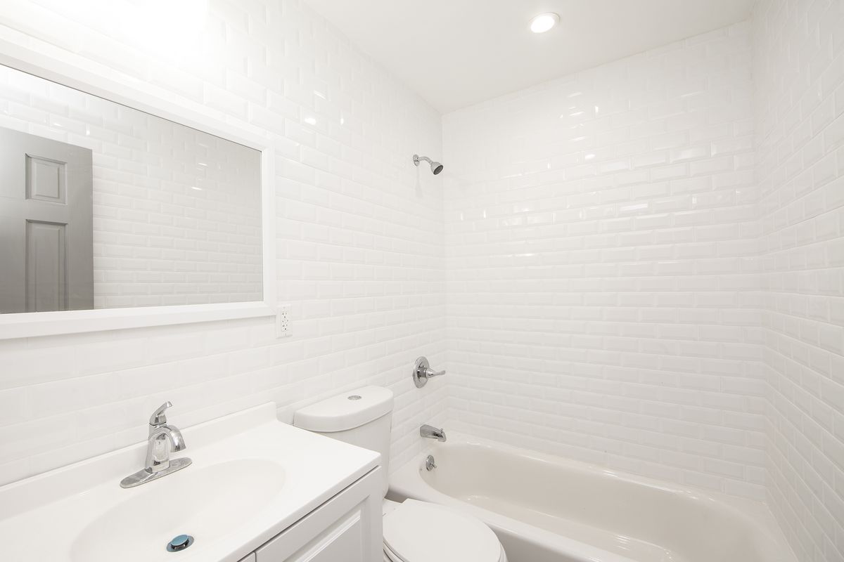 A bathroom with white tiles. 