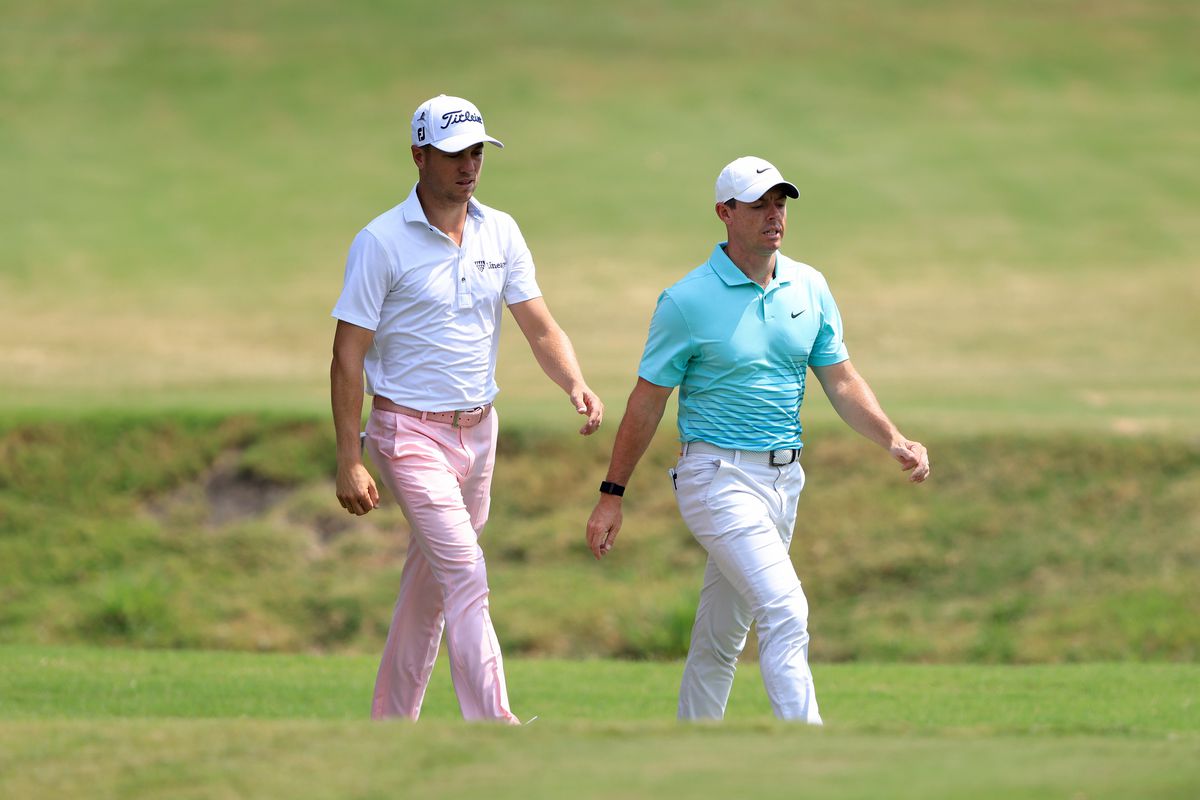 Justin Thomas and Rory McIlroy of Ireland walk down the first hole during the final round of the World Golf Championship-FedEx St Jude Invitational at TPC Southwind on August 08, 2021 in Memphis, Tennessee.