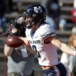 Utah State wide receiver Derek Wright celebrates while scoring a touchdown against New Mexico during the first half of an NCAA college football game on Friday, Nov. 26, 2021, in Albuquerque, N.M.