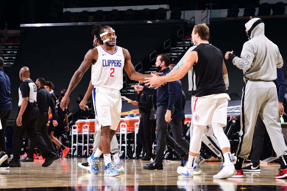 Kawhi Leonard of the LA Clippers high fives a teammate during the game against the Phoenix Suns on January 3, 2021 at Talking Stick Resort Arena in Phoenix, Arizona.