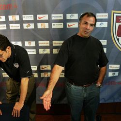 FILE - In this June 23, 2006, file photo, United States team manager Bruce Arena, right, speaks to journalists about being eliminated from the 2006 soccer World Cup at a news conference in Hamburg, Germany, as press officer Michael Kammarman listens at left. Arena is returning to coach the U.S. national team, a decade after he was fired.  The winningest coach in American national team history, Arena took over Tuesday, Nov. 22, 2016, one day after Jurgen Klinsmann was fired.  