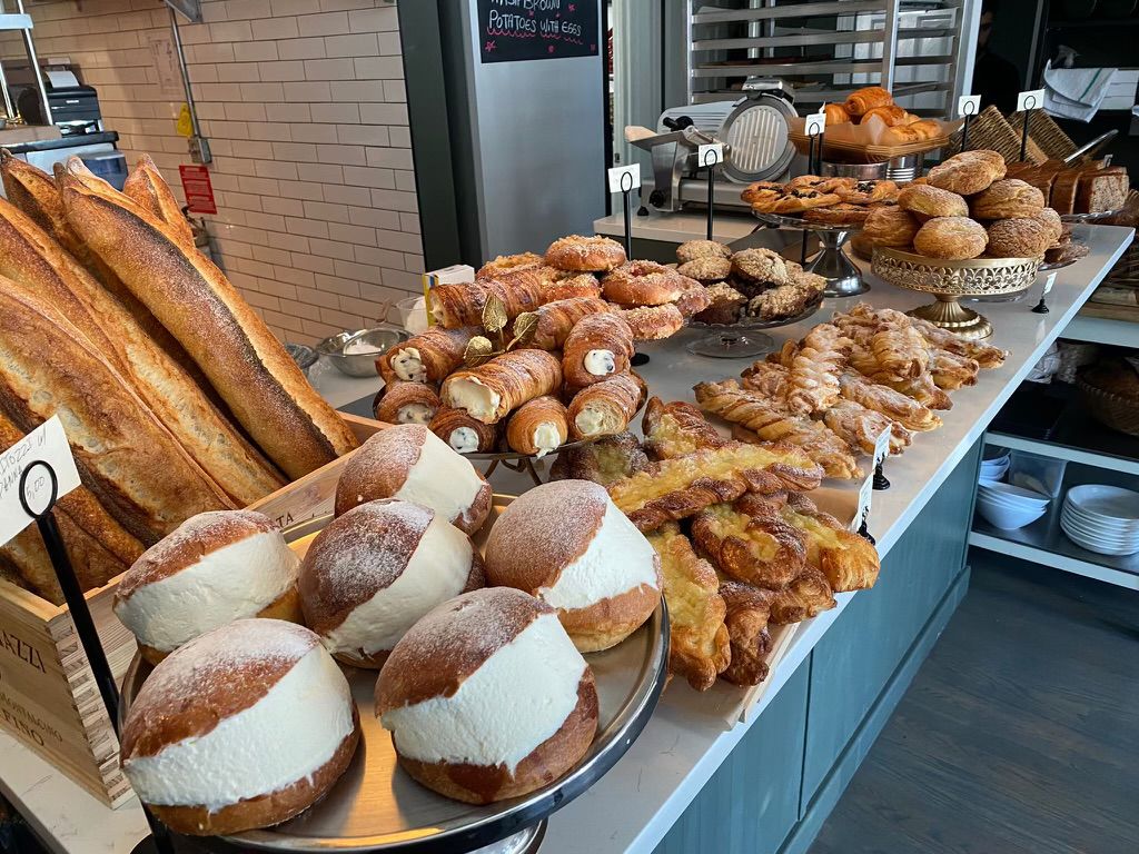 A variety of croissants, baguettes, muffins, and other pastries displayed on the restaurant’s bar countertop.