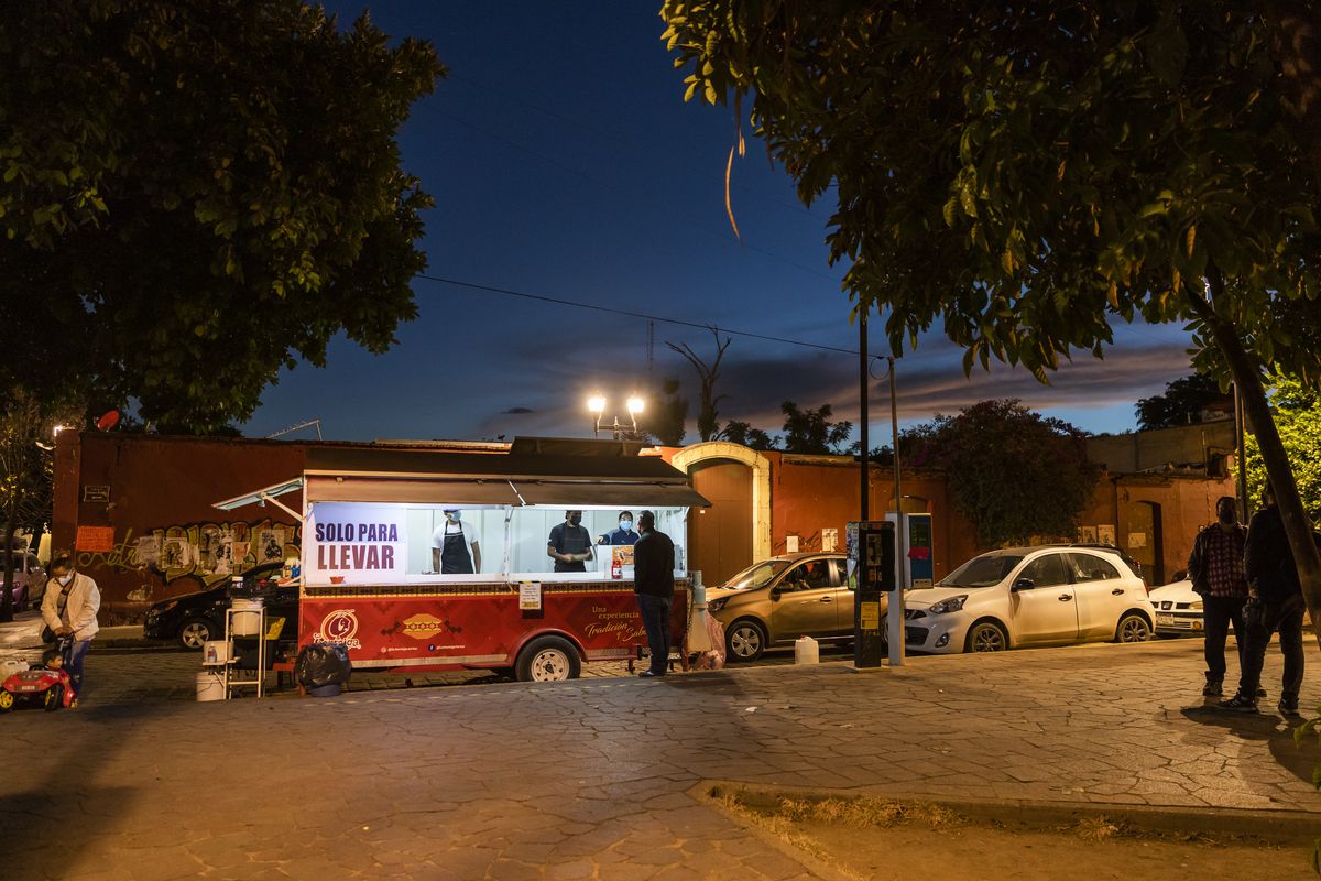 A food truck at the edge of a plaza at night