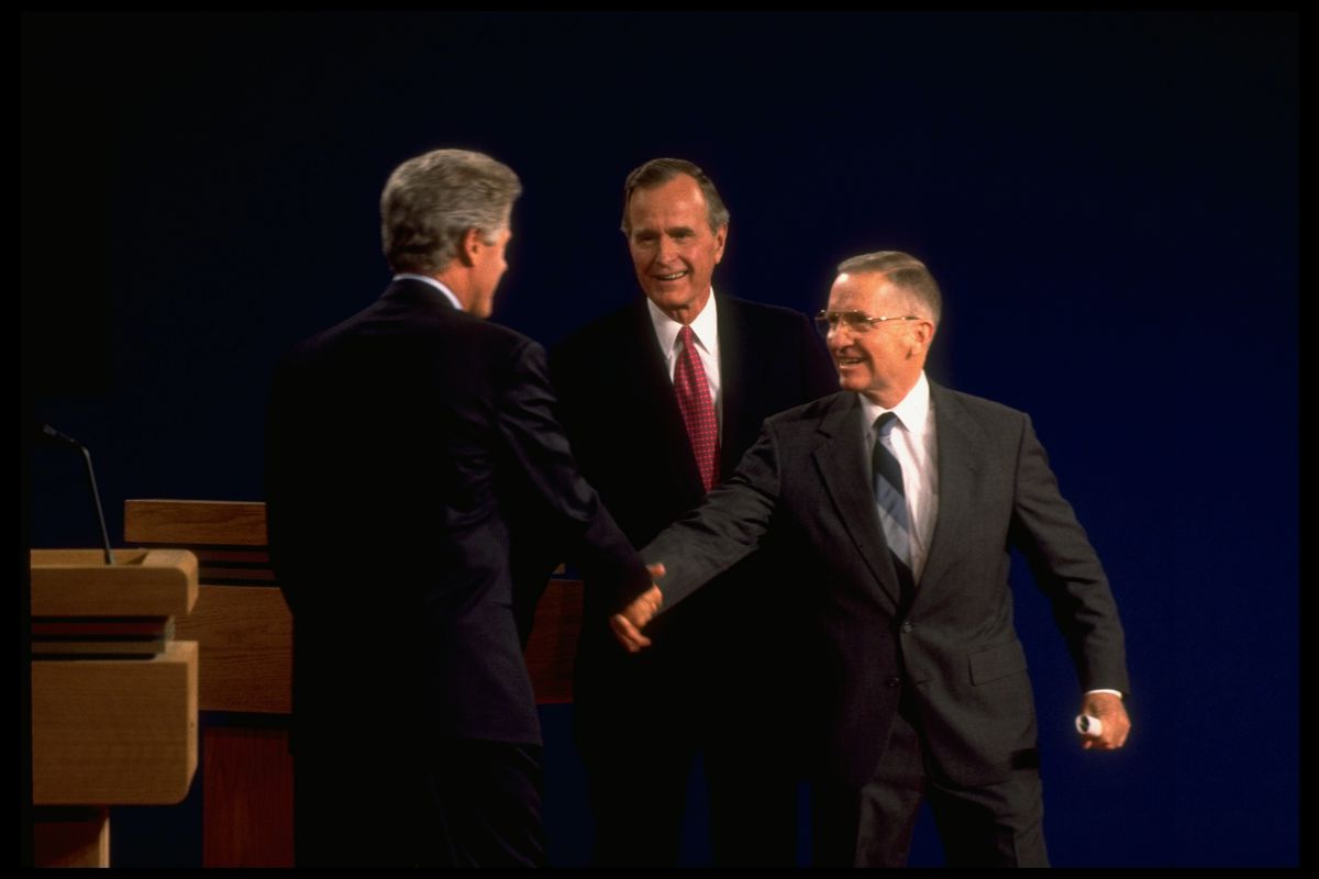 Perot (right) shakes hands with Bill Clinton as then-President George Bush looks on during the third presidential debate of 1992.