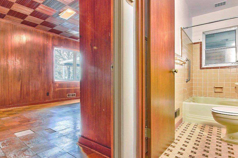 An old wooded bathroom, with a 1950s pink and brown bathroom at right. 