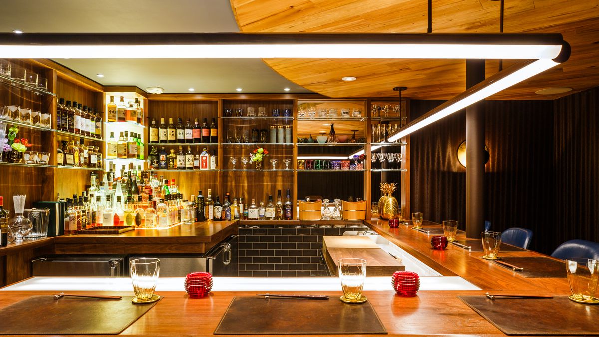 A black walnut countertop doubles as a cocktail bar and sushi counter at Uchu, a restaurant on the Lower East Side.