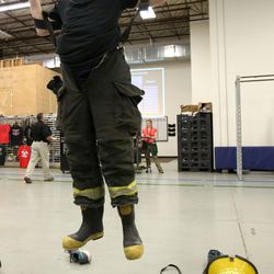 Dallin Beck, a Utah Valley University Firefighter Recruit Candidate Academy student, competes in the turnout drill against academy alumni during the Fire Games at the Utah Fire and Rescue Academy in Provo on Wednesday, Dec. 14, 2016. The annual games give the students — who graduated later Wednesday night — and academy alumni a chance to show off their skills and physical preparation in a series of events geared toward job-related functions. In addition to the turnout drill, participants competed in a tire pull and tug of war, did pullups, performed a bucket brigade — all in the name of fun and competition.