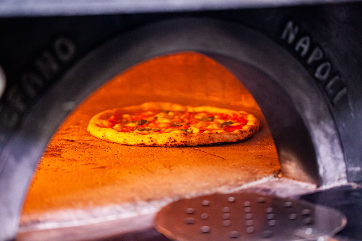 A margherita pizza finishes baking in the oven at Varuni Napoli in Atlanta. 