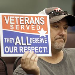 Steve Damron, 50, of Spring Hill, Fla., holds up a sign during a Hillsborough County Commission meeting about possible moving of a Confederate statue Wednesday, Aug. 16, 2017, in Tampa, Fla. Damron said the President Donald Trump handled the Charlottesville situation well, and he agreed with Trump that "both sides" were to blame.
