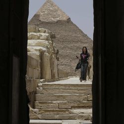 In this photo taken Friday, May 31, 2013, a tourist visits the Giza Pyramids in Giza, Egypt. A statement by Egypt’s Antiquities’ Ministry Saturday, June 1, 2013 says a U.S. Embassy security warning sent to citizens to be extra cautious for their safety in the area of the Pyramids is baseless. Earlier in the week, the U.S. Embassy in Cairo sent a message to its citizens warning them to “elevate their situational awareness when traveling to the Pyramids” due to a “lack of visible security or police” in the area. 