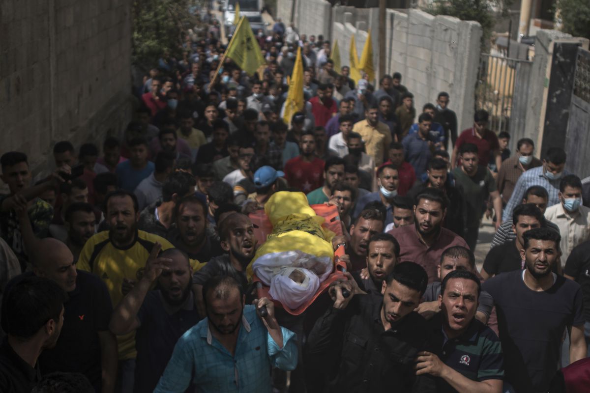 Palestinian mourners carry the body of 11-year-old Hussain Hamad, who was killed by an explosion during the ongoing conflict between Israel and Hamas, during his funeral in Beit Hanoun, northern Gaza Strip, Tuesday, May 11, 2021.
