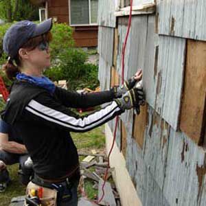 <p>Copy chief Leslie Monthan checks the fit on one of the dozens of shingles she replaced during siding duty at TOH's 2006 Americares project.</p>