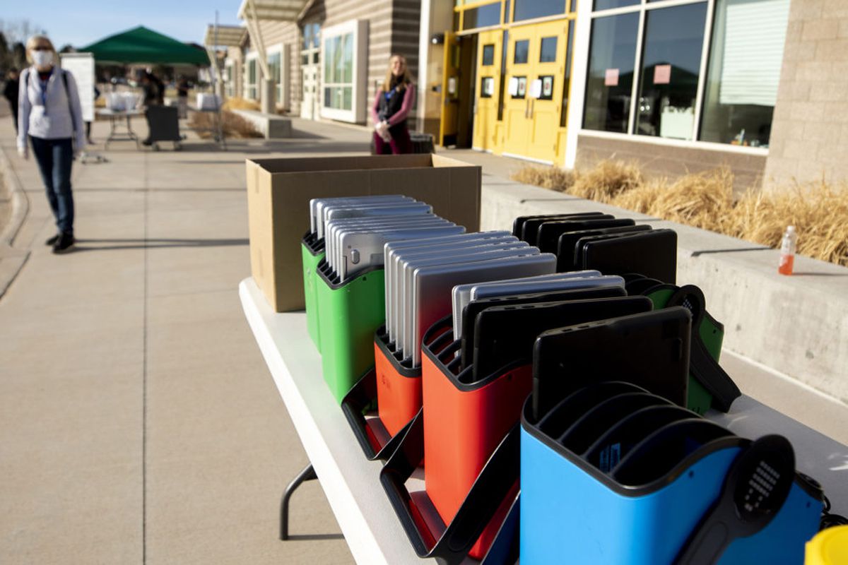 Staff distribute laptops to families at Denver’s Joe Shoemaker School on March 25, 2020, as schools prepare for remote learning.