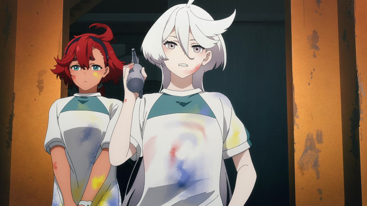 Suletta Mercury nervously stands behind Miorine, who’s holding an airbrush. Both are wearing matching paint-stained t-shirts in a scene from Mobile Suit Gundam: The Witch from Mercury.