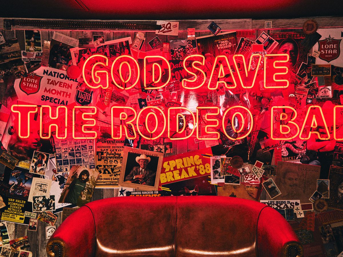 A neon sign reads “God save the Rodeo Bar.”