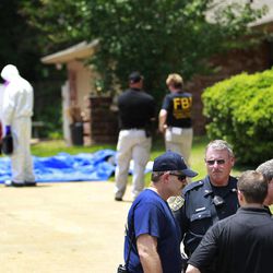 FILE - In this May 31, 2013 file photo, authorities search a residence in New Boston, Texas in connection with a federal investigation surrounding ricin-laced letters mailed to President Barack Obama and New York Mayor Michael Bloomberg. Two U.S. law enforcement officials say Shannon Richardson of New Boston, Texas, has been arrested Friday, June 7, in the investigation. 