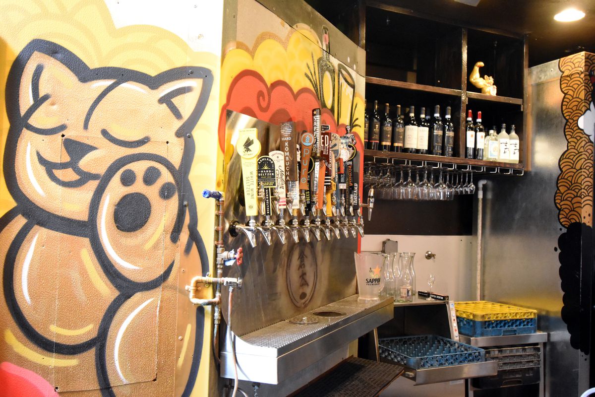 Beet taps with Japanese-style golden lucky cat mural.