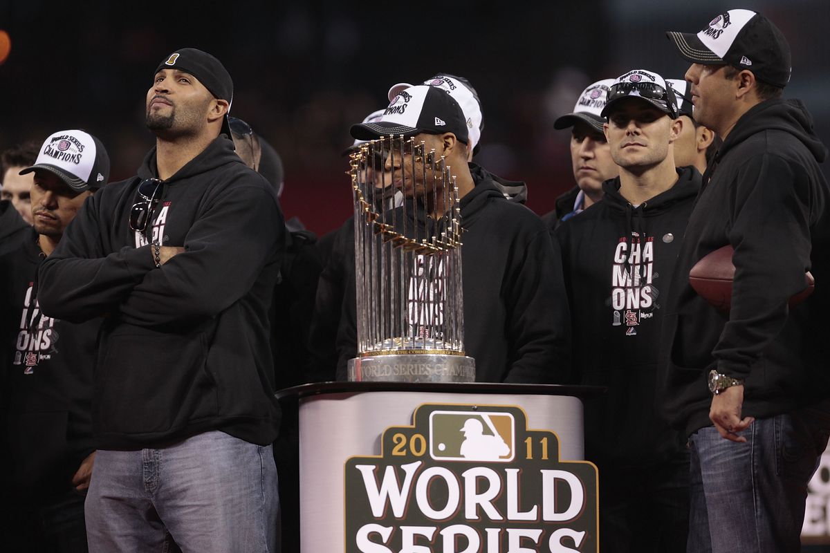 Albert Pujols, along with other members of the Cardinals, stands with the 2011 World Series trophy