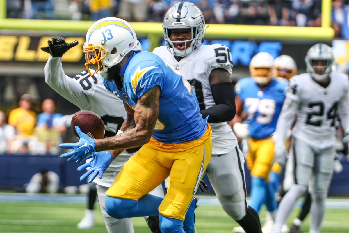 Los Angeles Chargers wide receiver Keenan Allen (13) hauls in a long pass from Los Angeles Chargers quarterback Justin Herbert (10) in the first quarter against the Las Vegas Raiders at SoFi Stadium.