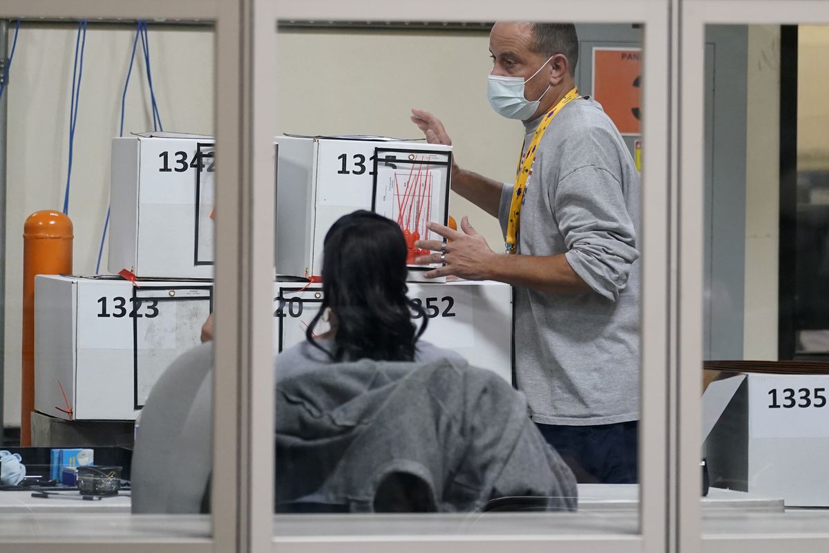 A county election worker moves boxes of mail-in ballots at a tabulating area at the Clark County Election Department, Thursday, Nov. 5, 2020, in Las Vegas.