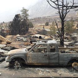Vehicles are burned and homes are reduced to rubble in the community of Swall Meadows, Calif., Sunday, Feb. 8, 2015. Fire crews increased containment of a wind-driven wildfire that destroyed 40 homes, but they said Sunday that they still didn't know when residents evacuated from two small California towns at the eastern base of the Sierra Nevada would be able to return home. 